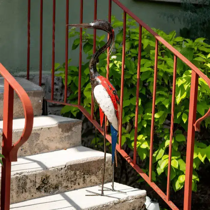 Sculpture d'héron en métal de récupération sur un escalier